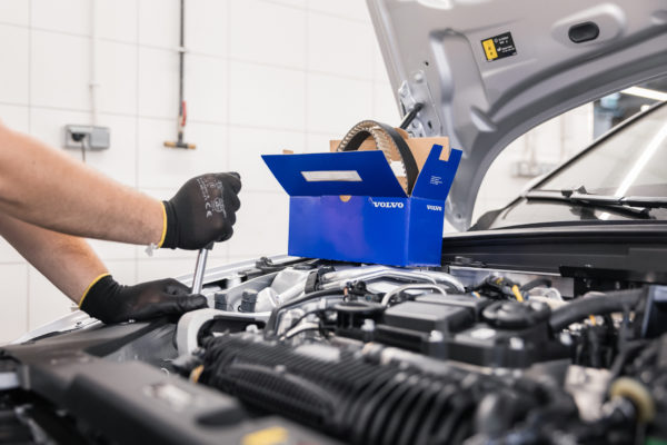 Naprawa rozrządu. Mechanik odkręca kluczem część.